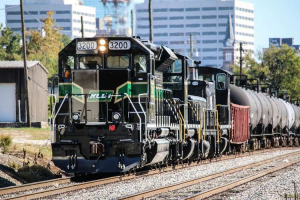 Knoxville Locomotive Works paint job on a large locomotive pulling a long train out of the city