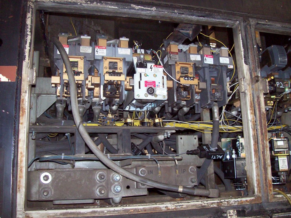 High voltage handling area of an MP15 locomotive, showing high voltage contactors, huge cables running through TMV 1800A current sensors to measure Armature current. Current Transducers.